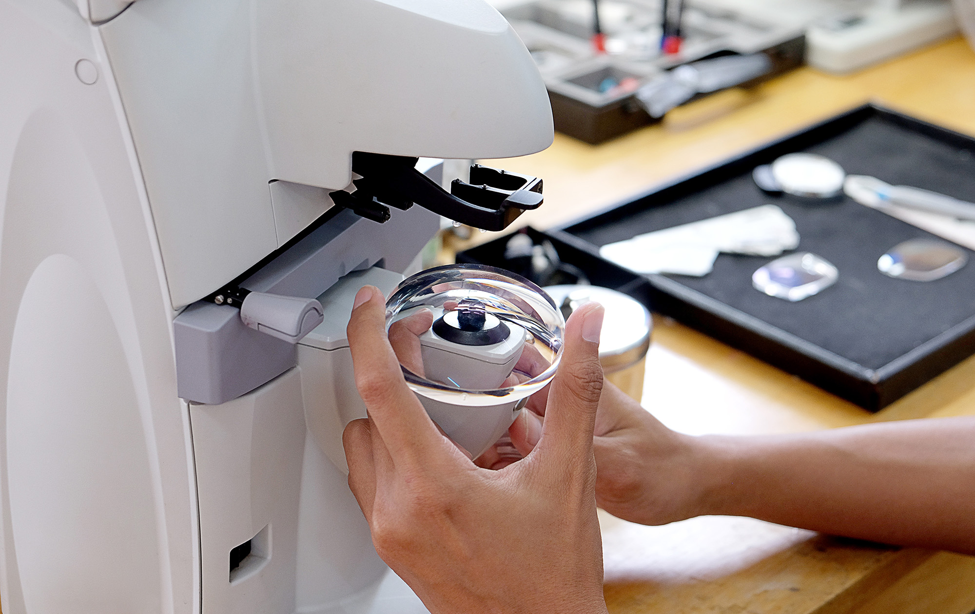 Soczewka optyczna umieszczona w specjalnym urządzeniu - proces produkcji okularów